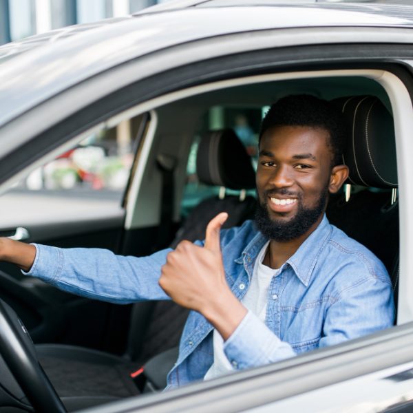 happy-african-businessman-giving-thumb-up-inside-new-car